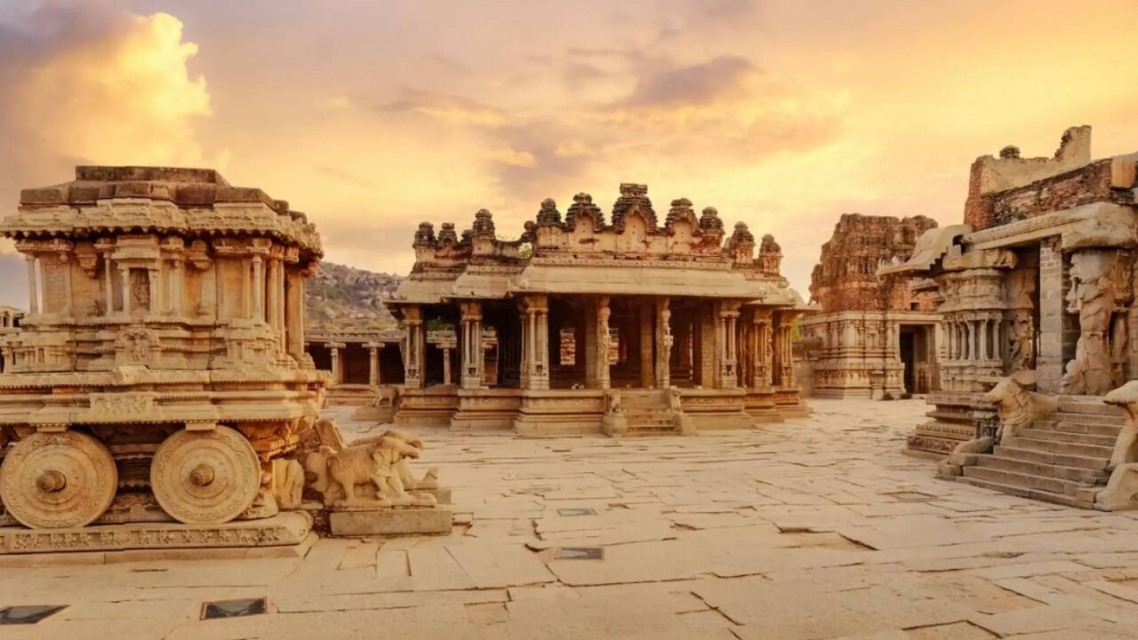 https://travelforless.us/wp-content/uploads/2024/09/antiguo-carro-de-piedra-con-ruinas-arqueologicas-en-el-patio-del-templo-vittala-en-hampi-karnataka-india-1-1280x720.jpg